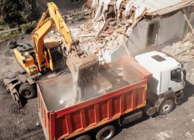Excavator,Bucket,Loads,Industrial,Debris,Into,Truck.,Process,Of,Demolishing